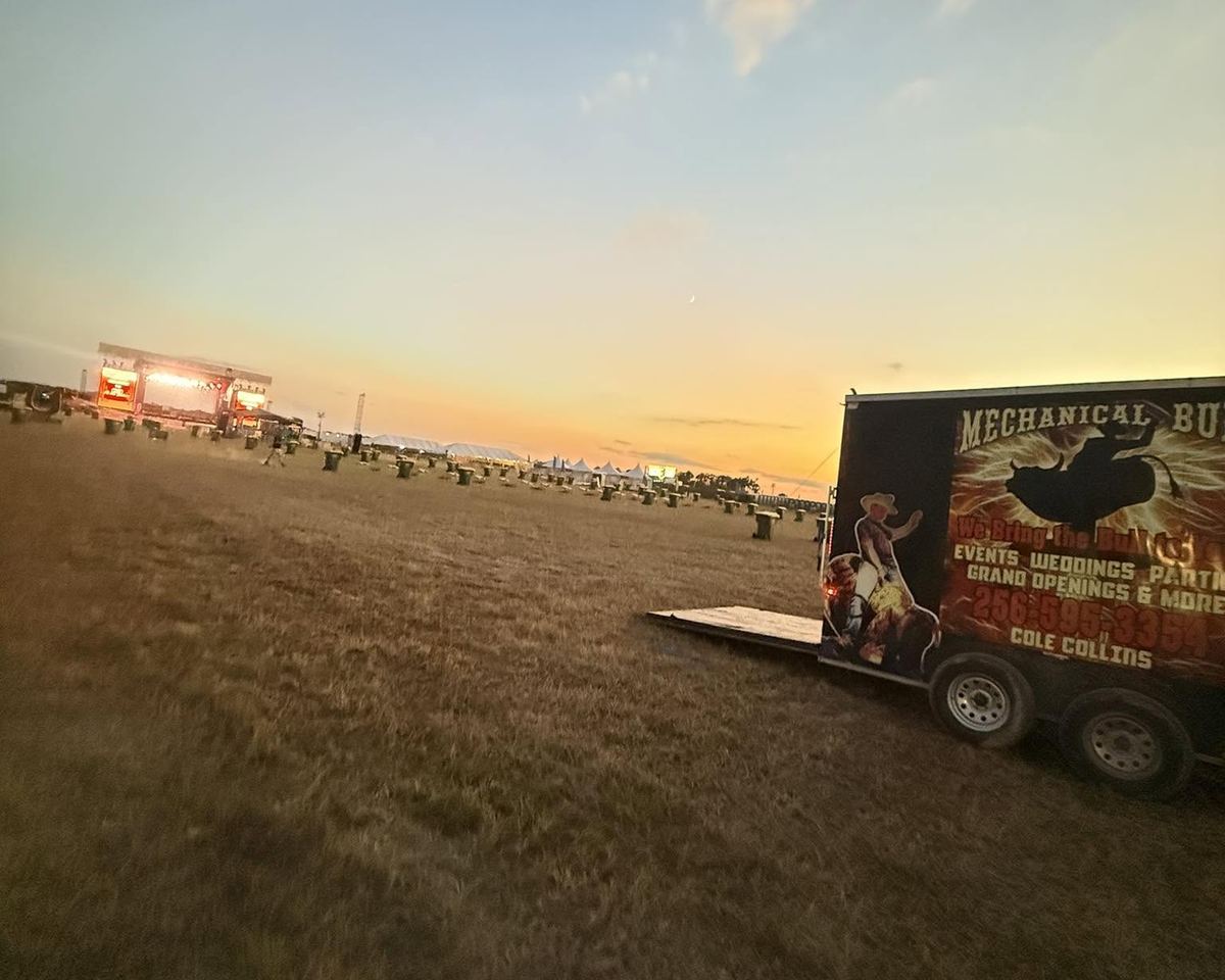 The Mechanical Bull of the South trailer parked in a festival field at sunset